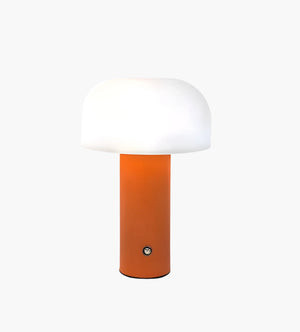 Modern table lamp with an orange cylindrical base and a white dome-shaped shade.