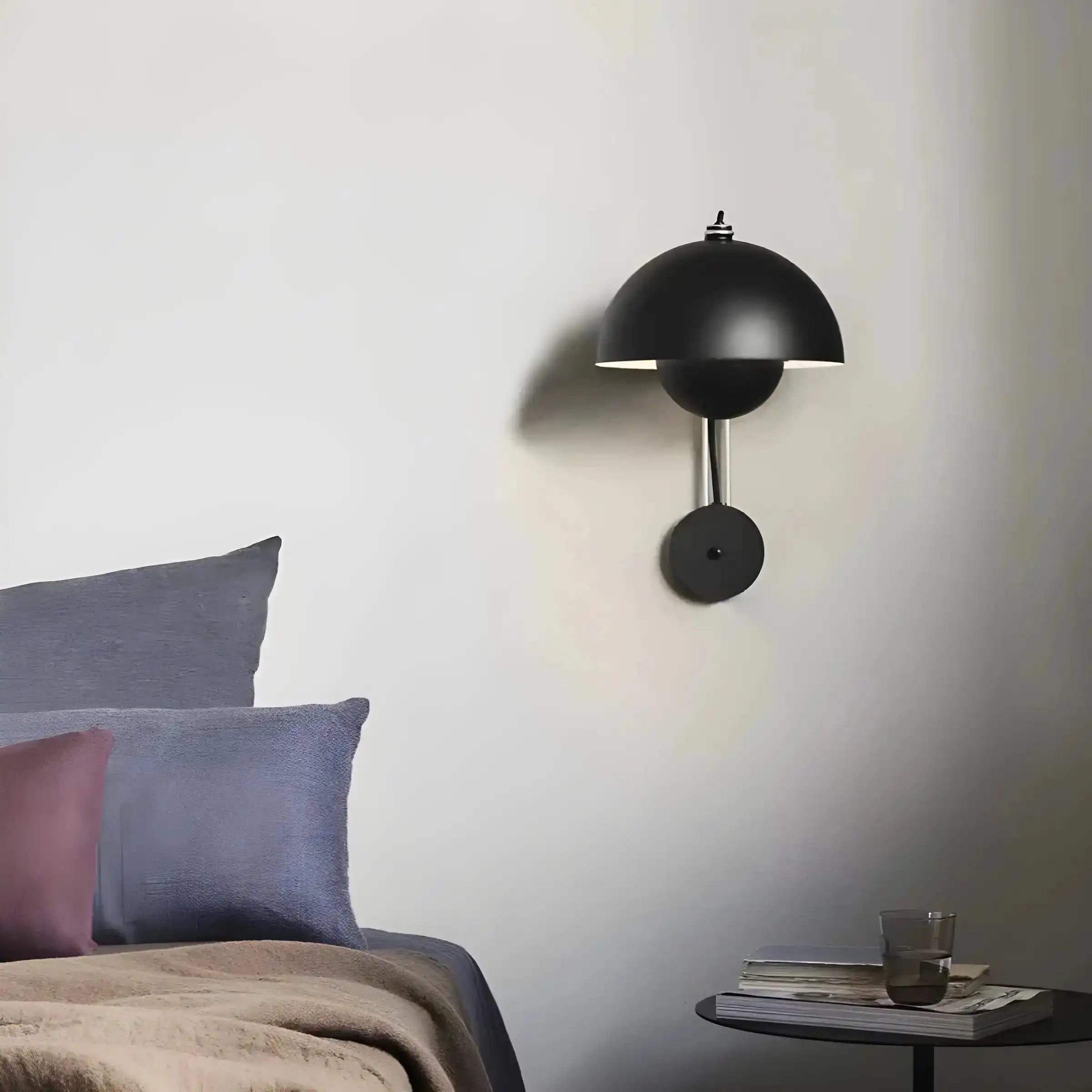 Black dome-shaped wall sconce with a circular base and slim arm.