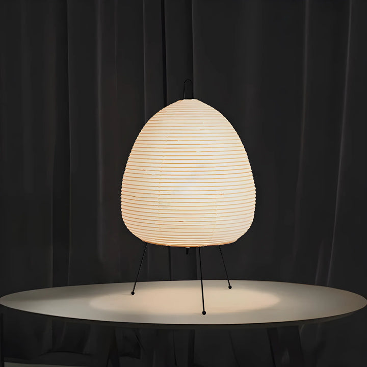 Egg-shaped paper lantern lamp on thin metal legs.