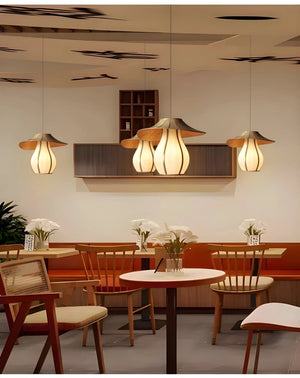 Elegant pendant lights with petal-like shades hanging above dining tables.