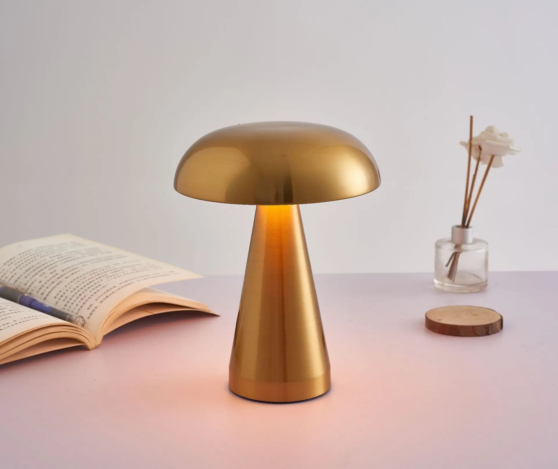 Gold-colored mushroom-shaped table lamp with a glowing light.