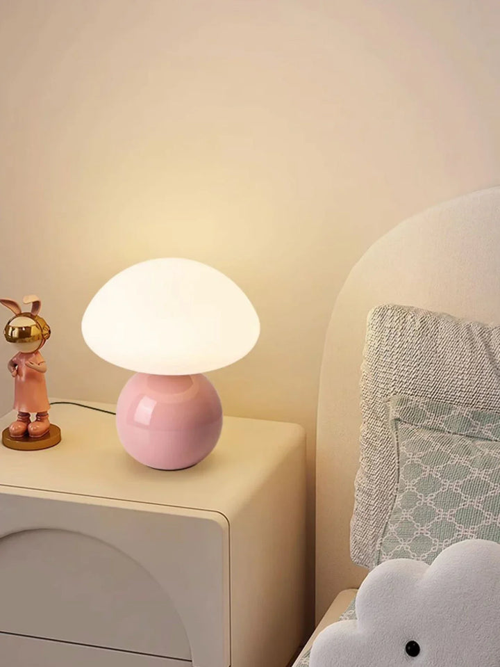 Mushroom-shaped table lamp with a pink base and white dome shade.