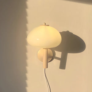 Mushroom-shaped table lamp with a round, glowing shade and curved stem.