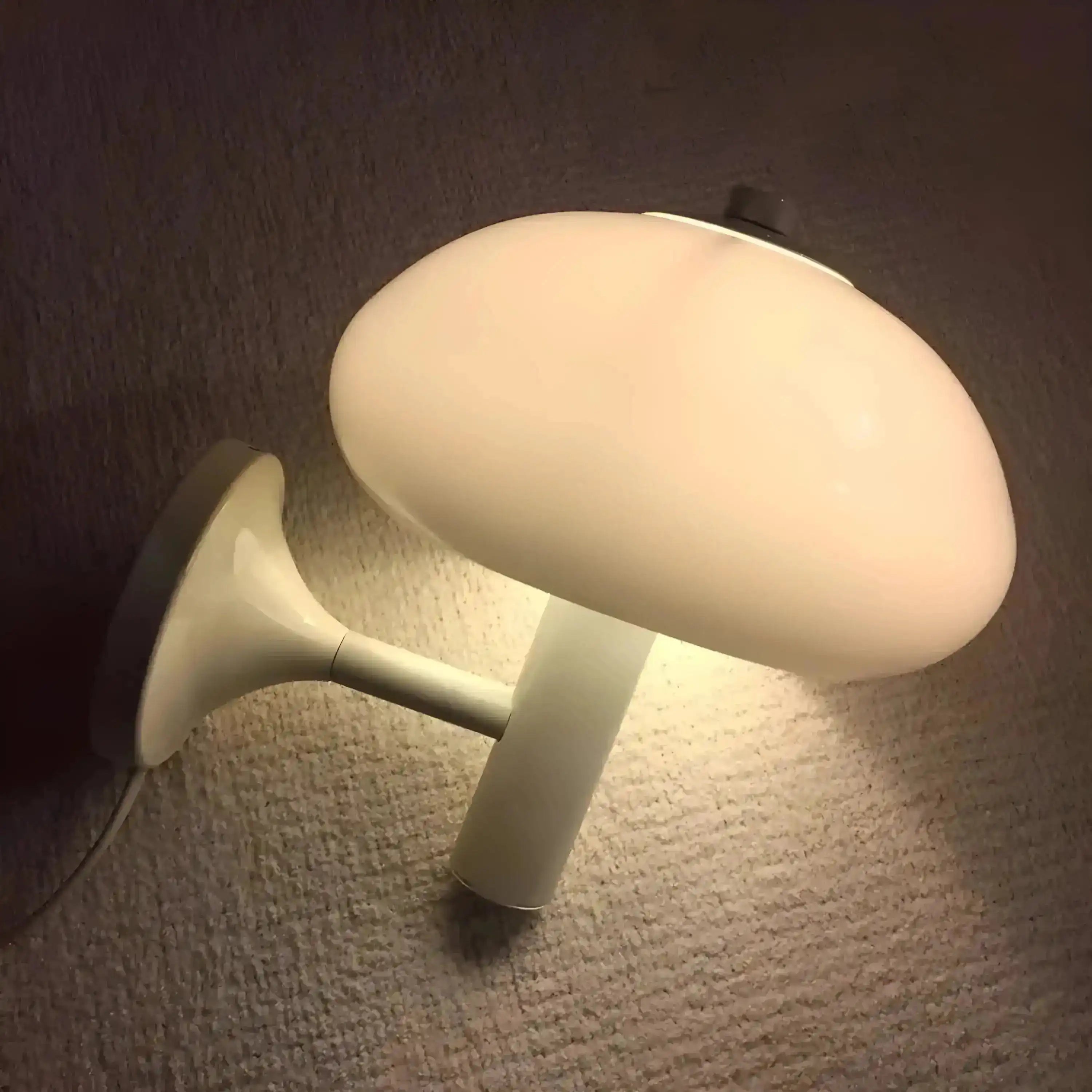 Mushroom-shaped wall lamp emitting a soft glow.