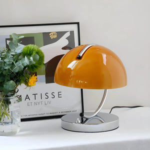 Orange dome-shaped table lamp with a chrome base.