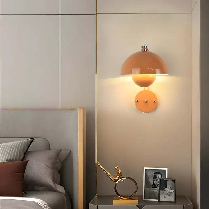 Peach-colored dome wall lamp with a warm, glowing light.