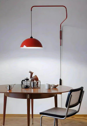 Red dome-shaped pendant lamp with an adjustable arm mounted on a wall.