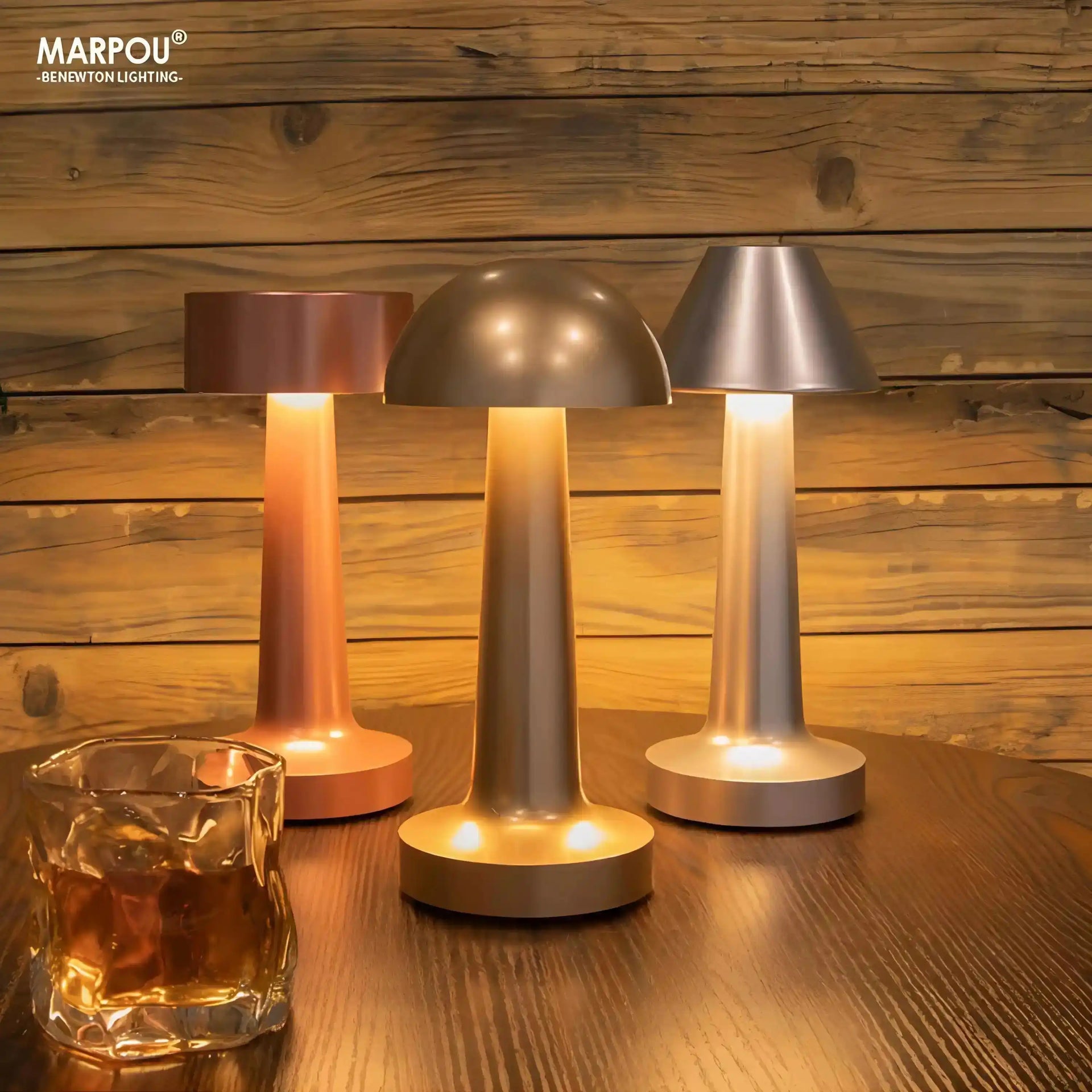 Set of three modern cordless table lamps with metallic shades and glowing bases.