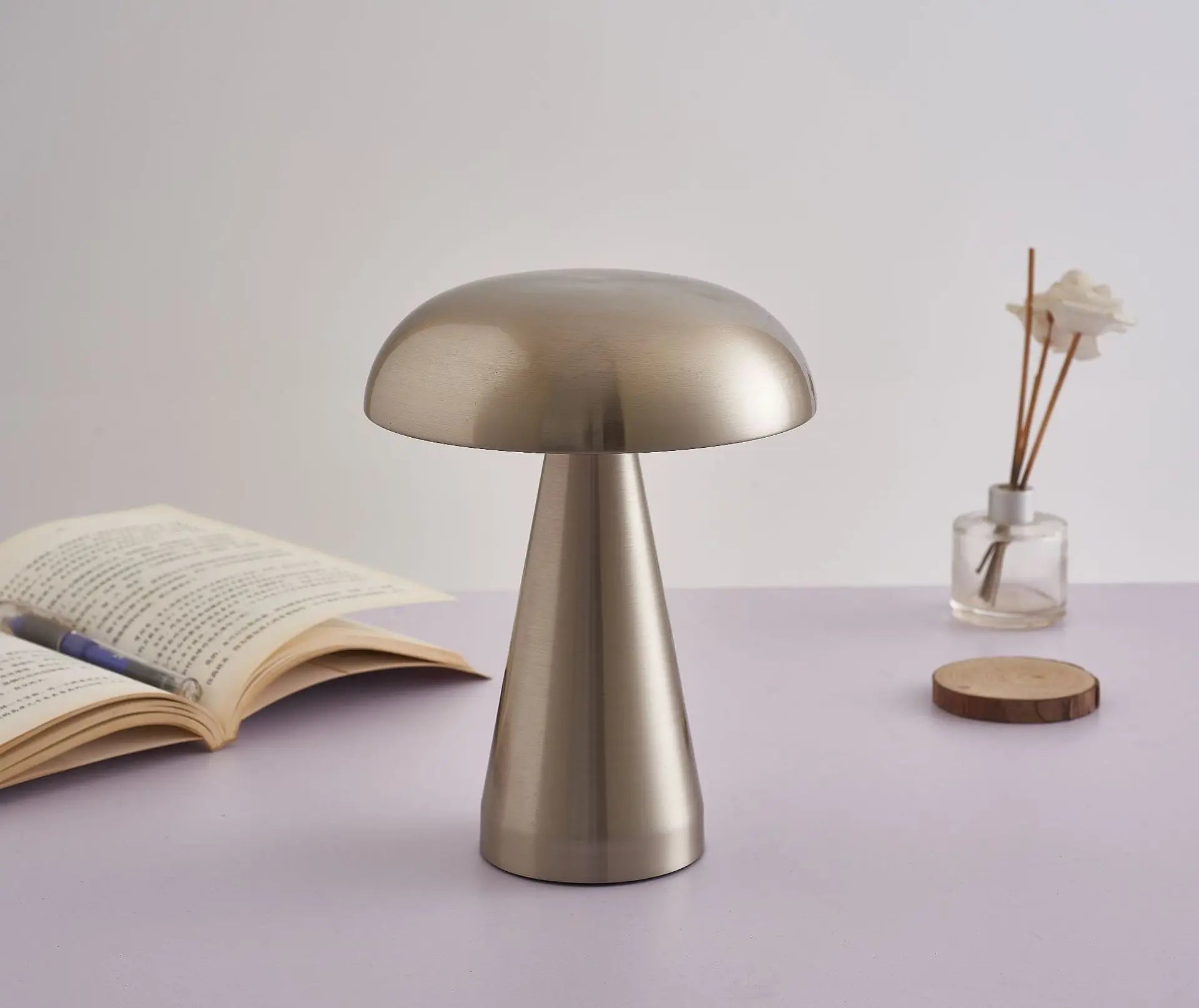 Metallic mushroom-shaped table lamp with a smooth, brushed finish.