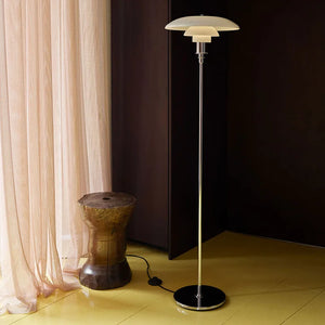 Sleek modern floor lamp with a tiered circular shade atop a slender metal stand.