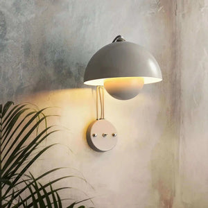 Wall-mounted lamp with a dome-shaped shade and metallic arm.