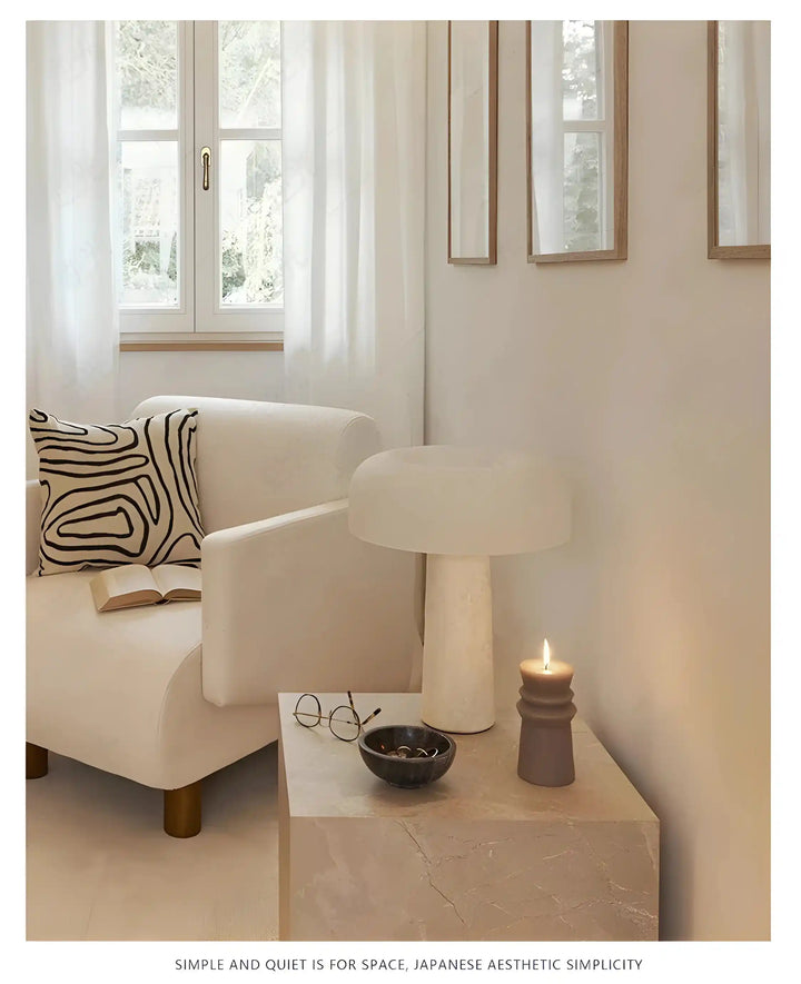 White mushroom-shaped table lamp on a light-colored surface.