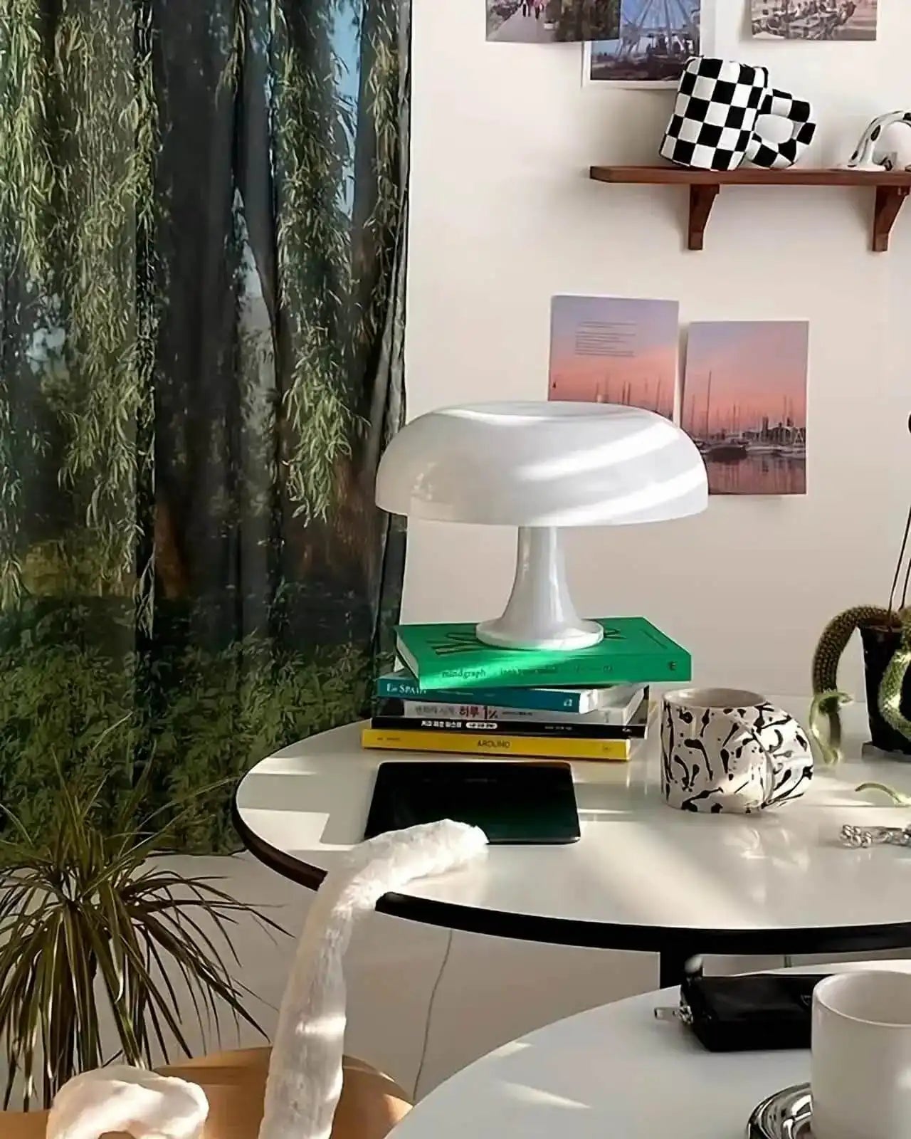 White mushroom-shaped table lamp on a stack of books.