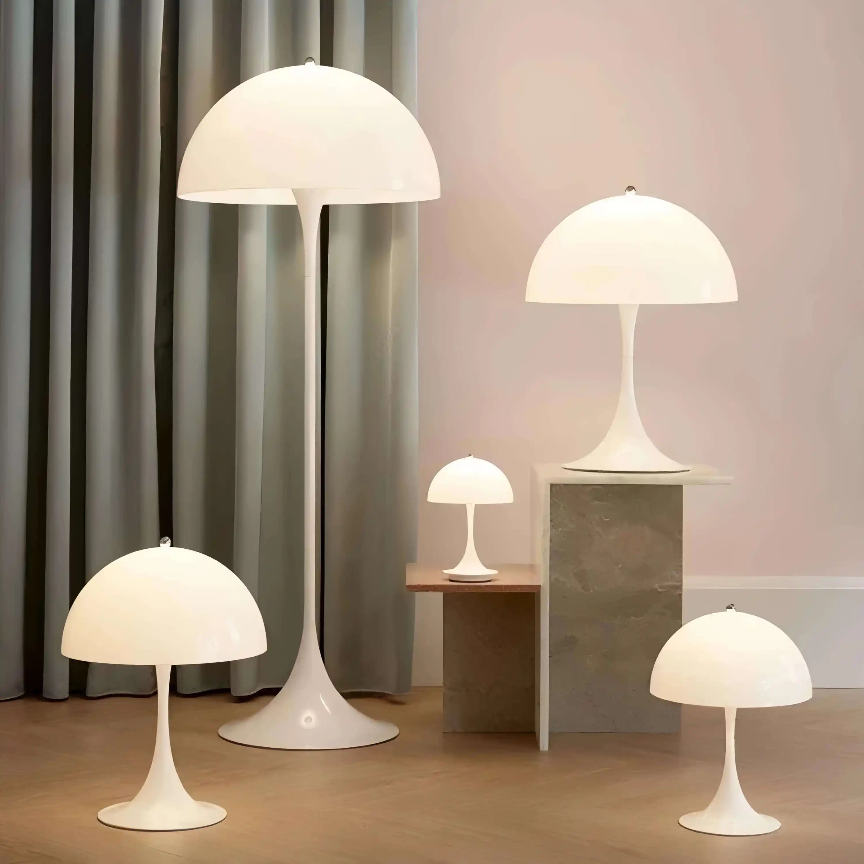 Set of white dome-shaped table and floor lamps with tulip-style bases.